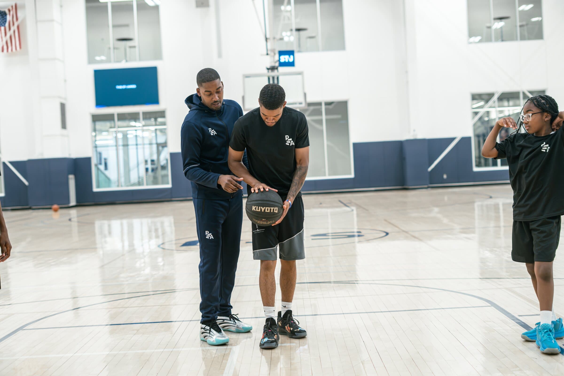 Rashad Petty correcting an athlete's basketball grip during a training session