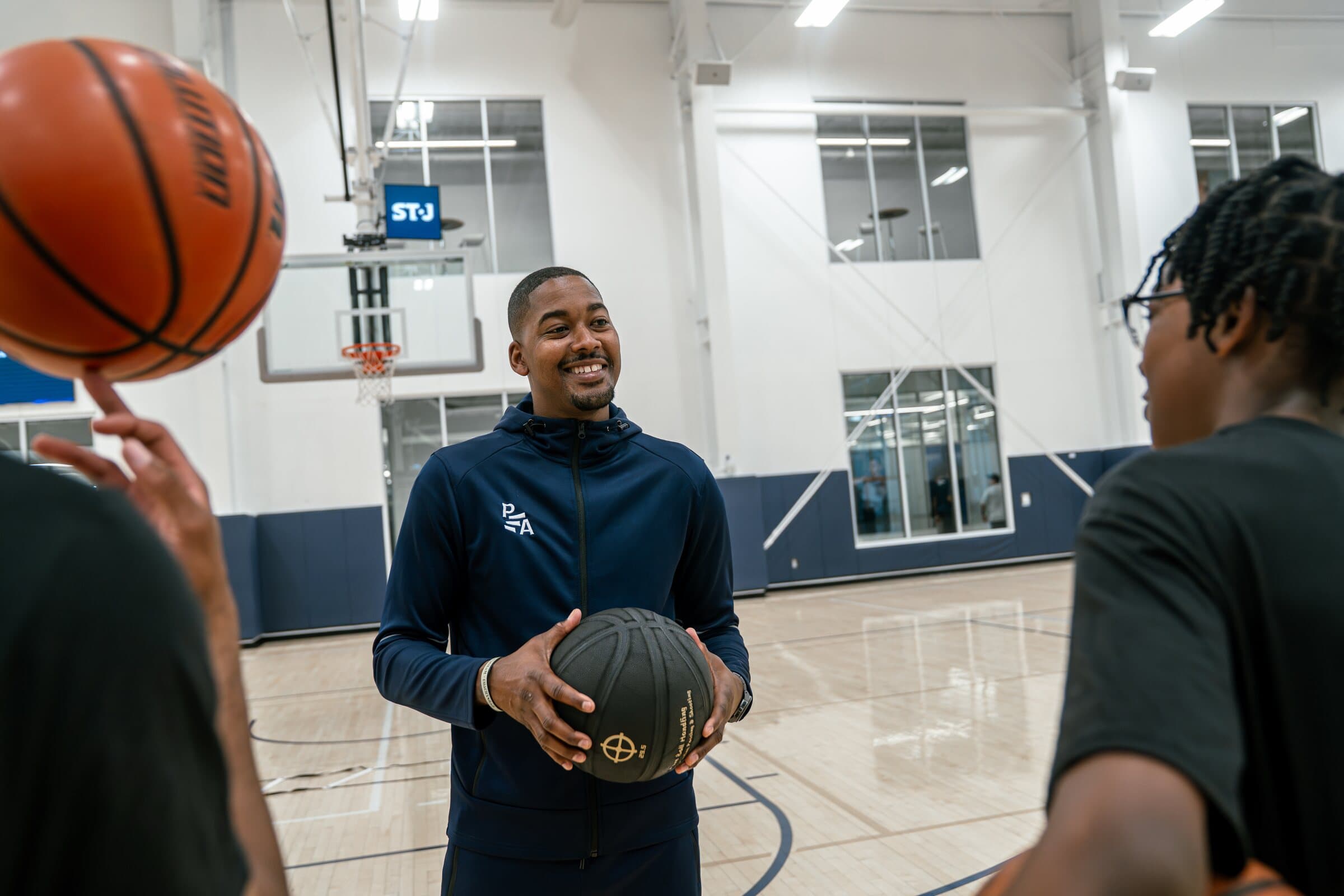Rashad Petty smiling while speaking with Petty Athletics athletes in the gym