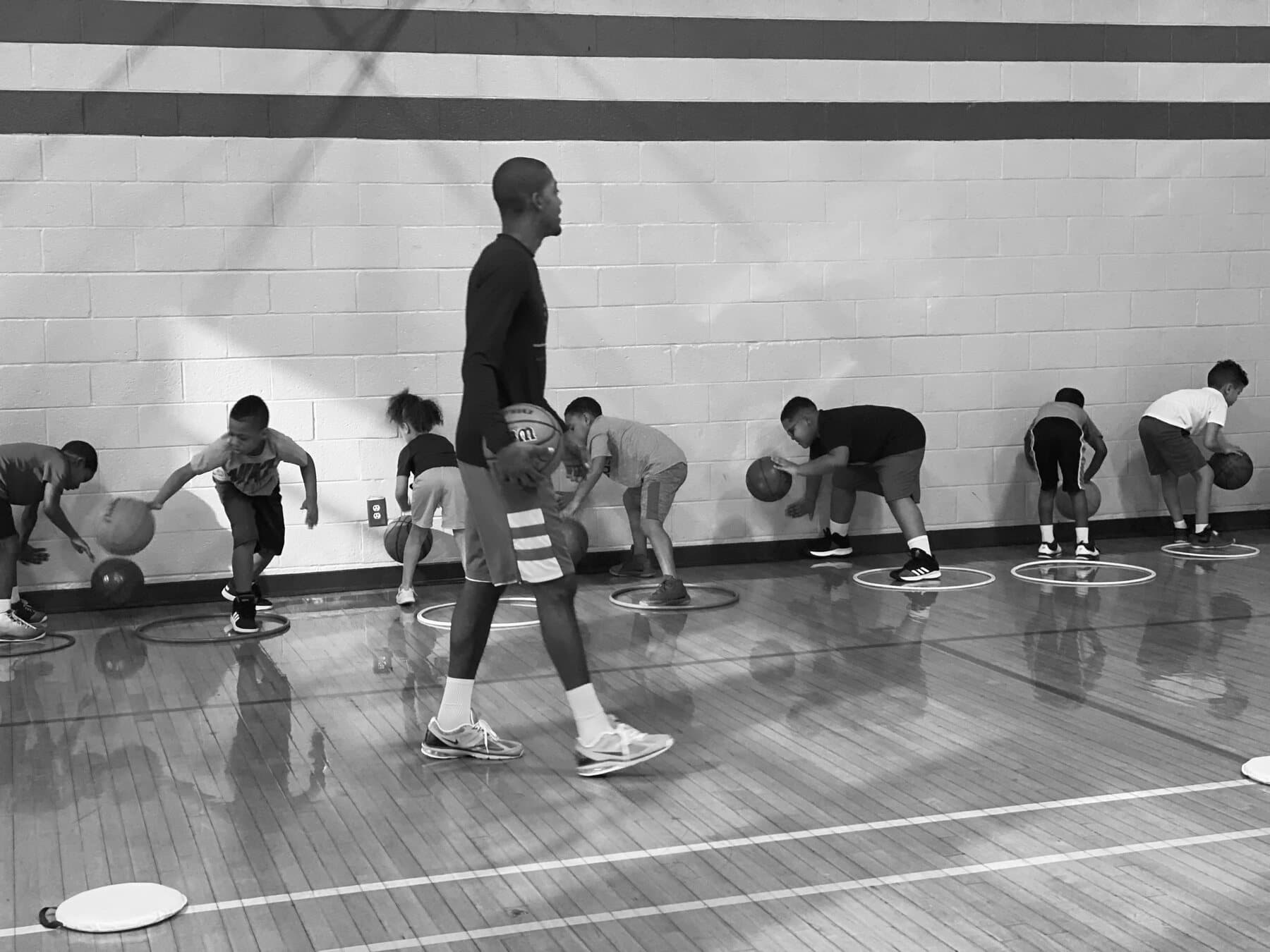 Rashad Petty leading a group of young athletes through a community basketball exercise