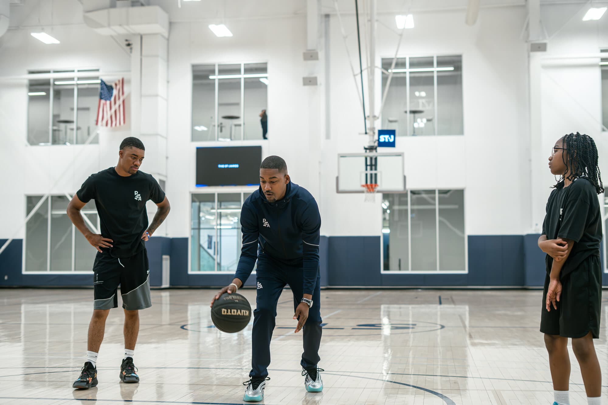 Rashad Petty, founder of Petty Athletics, coaching two youth basketball athletes in a gym