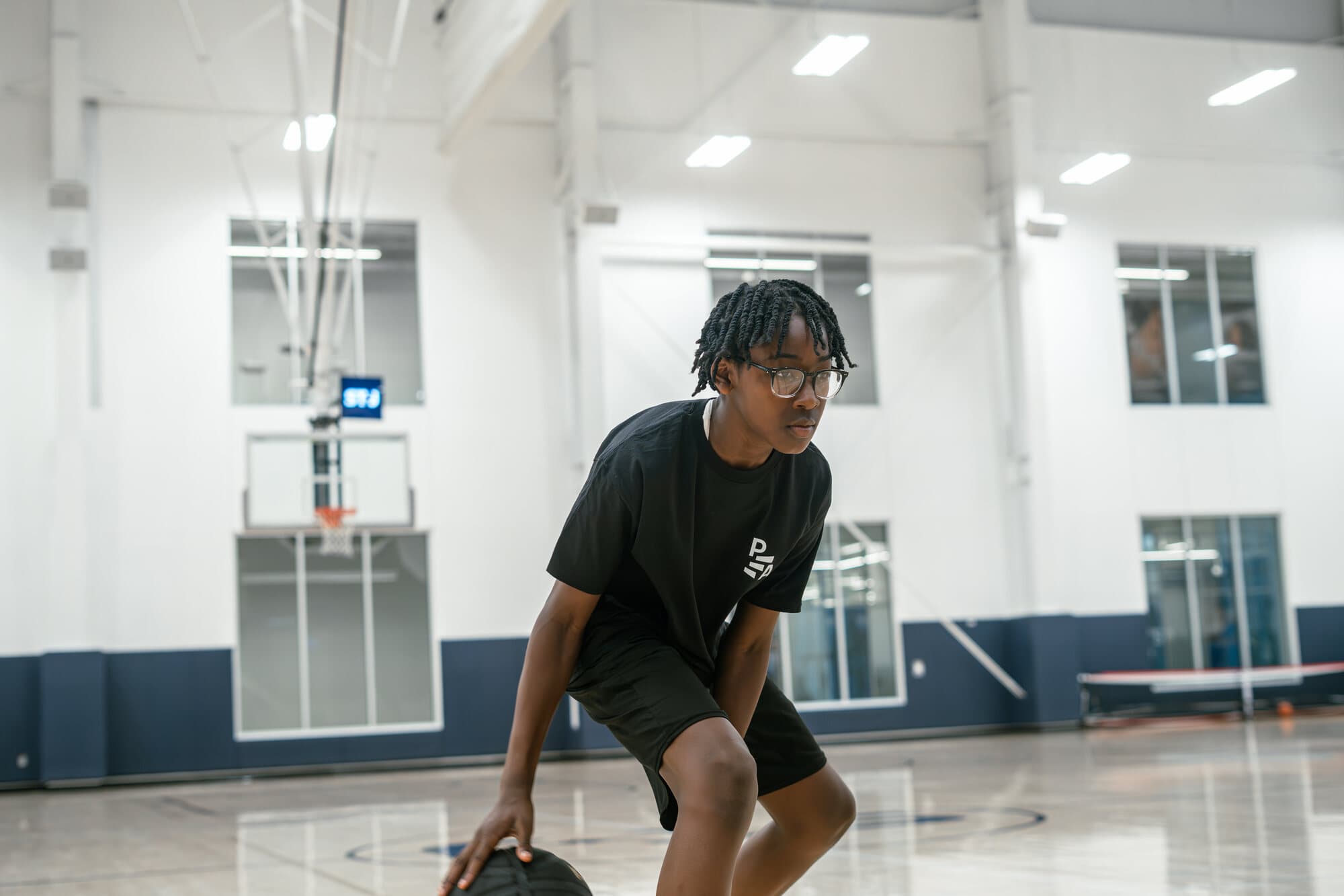 A youth athlete training on an indoor basketball court